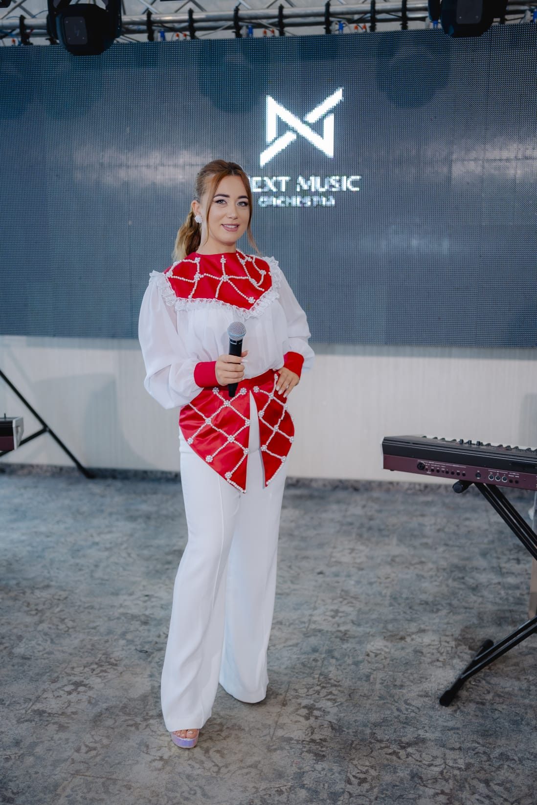 Solista de muzică populară în costum tradițional alb cu roșu